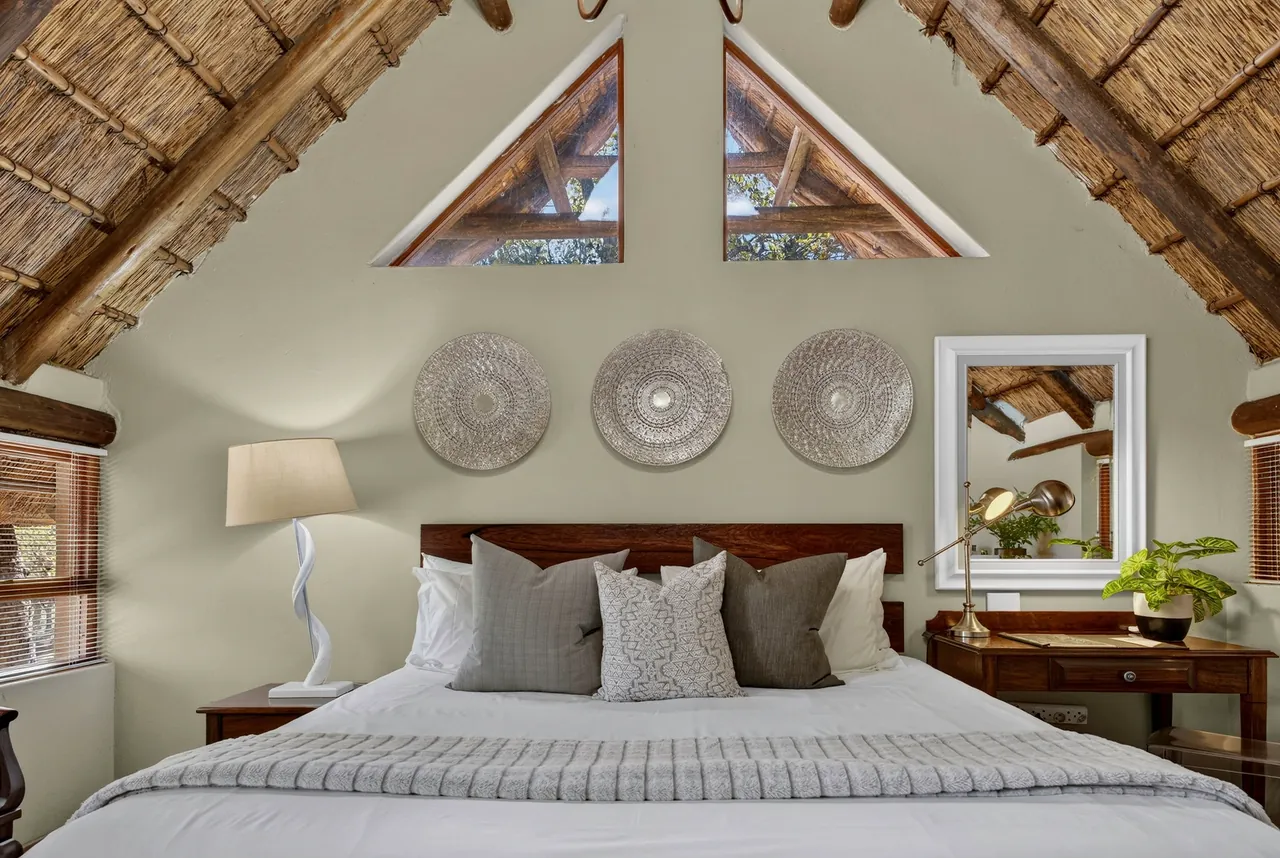 Bedroom with a thatched gable and three woven wall plates above the bed