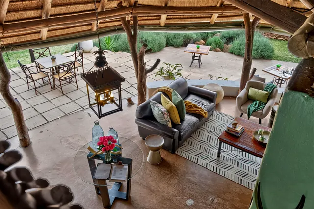 Lounge seen from above, opening onto a terrace with tables and a garden