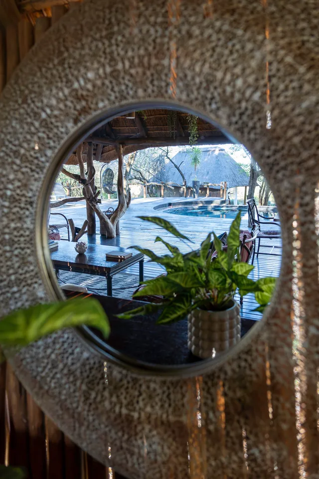 The pool and lounge reflected in a round, textured mirror