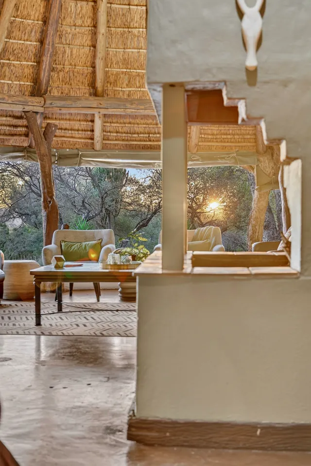 Thatched lounge and stairs at sunset, reflected in a mirror