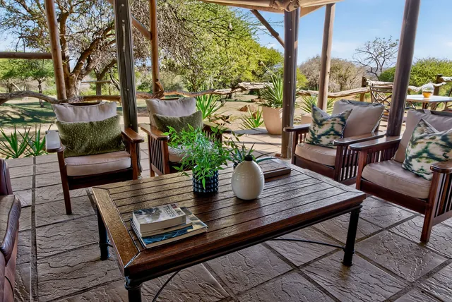 Shaded veranda with cushioned armchairs around a timber coffee table